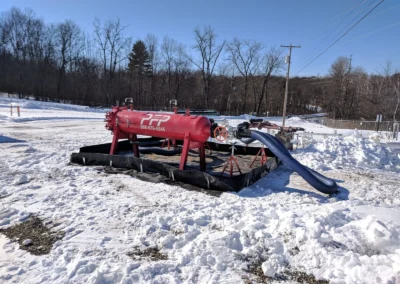Horizontal high flow filter vessel on site in snowy conditions with transfer hoses connected for fluid filtration