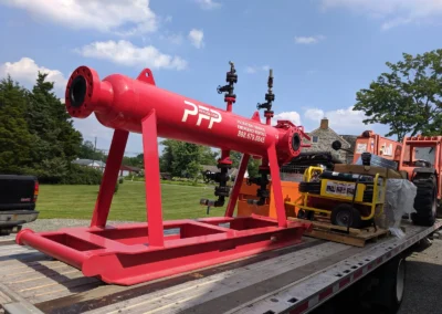 Horizontal high flow filter vessel secured on a truck bed, prepared for shipment to customer site for industrial filtration
