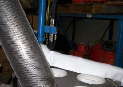 Technician loading liquid bag filters into an open bag filter housing during setup or maintenance